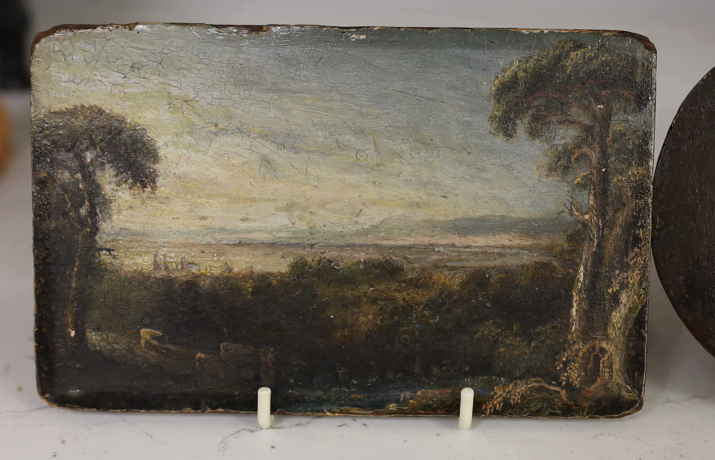 A 19th century oil on panel, Pastoral landscape, unframed, together with a Dutch oval oil on panel, three figures in an interior, largest 11 x 17.5cm